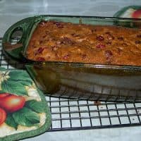 Whole. wheat cranberry nut bread in a glass loaf pan.