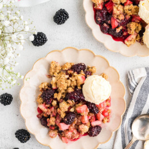 Apple blackberry crumble on plates with vanilla ice cream.