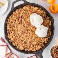 Apricot crumble in a cast iron skillet with two scoops of ice cream.
