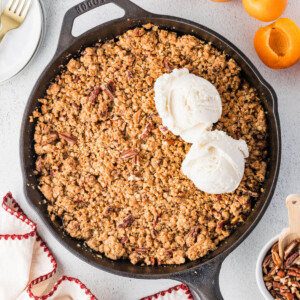 Apricot crumble in a cast iron skillet with two scoops of ice cream.