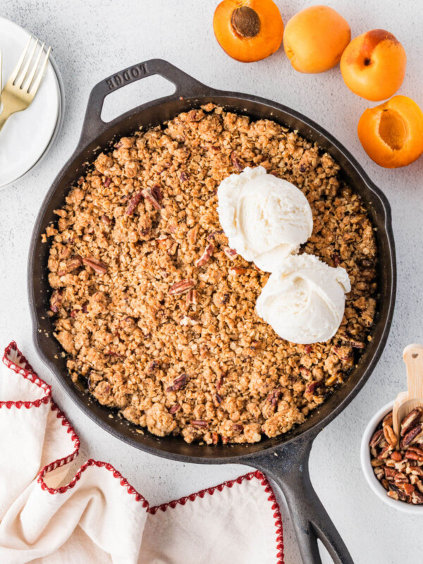 Apricot crumble in a cast iron skillet with two scoops of ice cream.