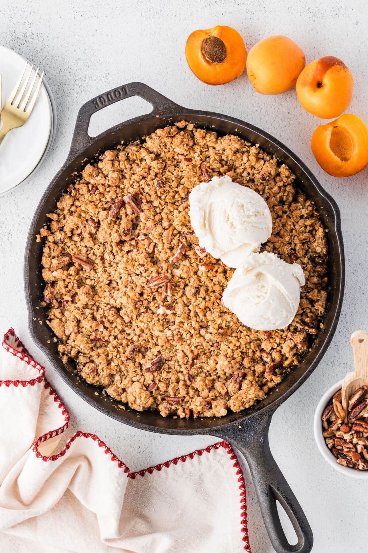 Apricot crumble in a cast iron skillet with two scoops of ice cream.
