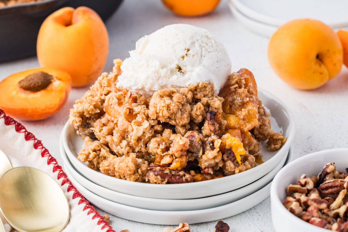 Apricot crumble on a plate with vanilla ice cream.