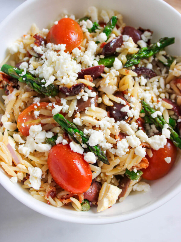Orzo salad with asparagus in a bowl.