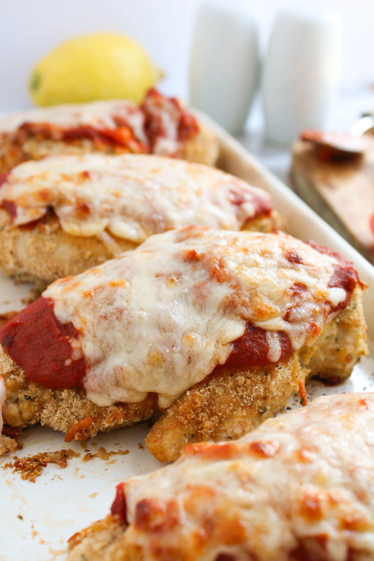 Pan of easy baked chicken parmesan with melted cheese on top.