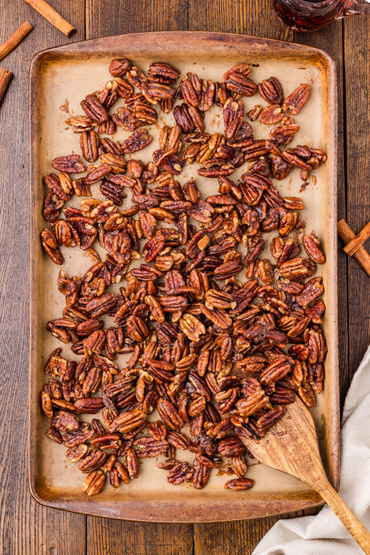 Candied maple pecans in an even layer on baking sheet.