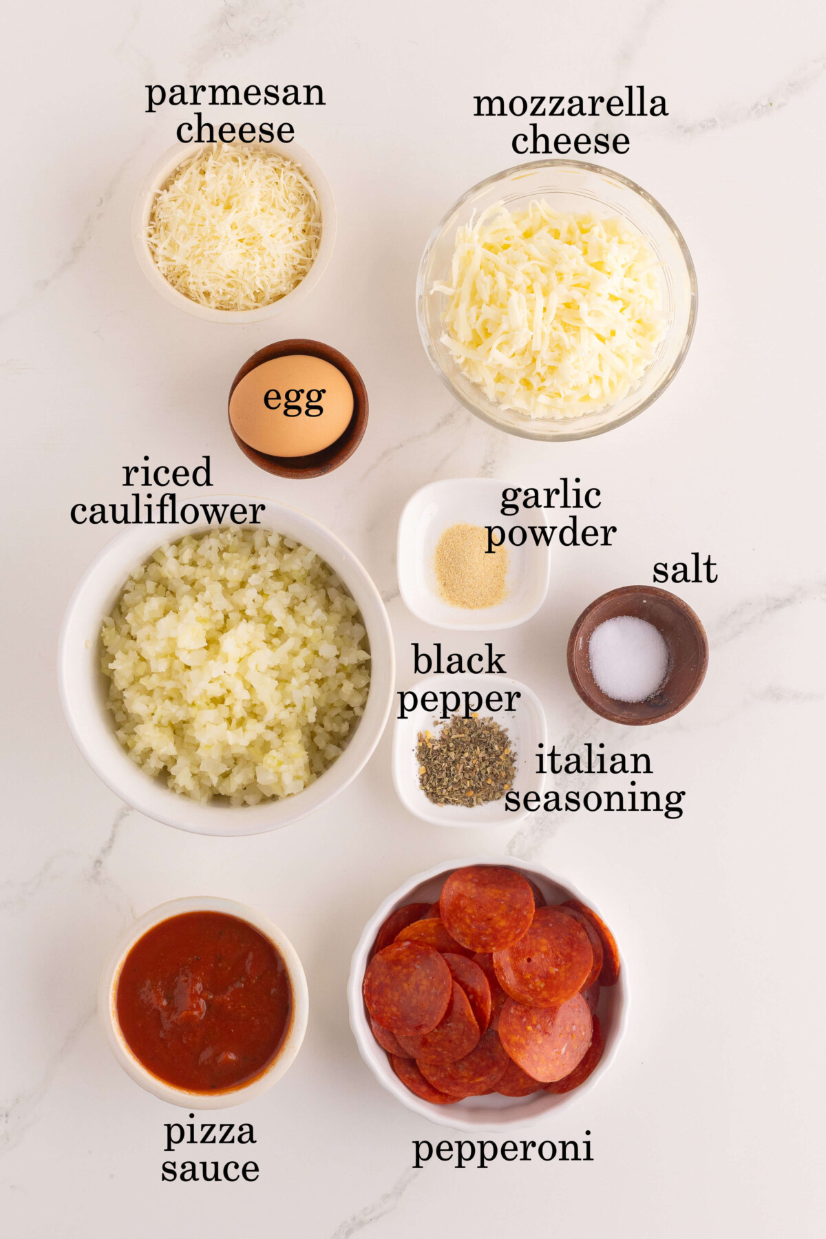 Ingredients for cauliflower pizza crust recipe in small bowls.