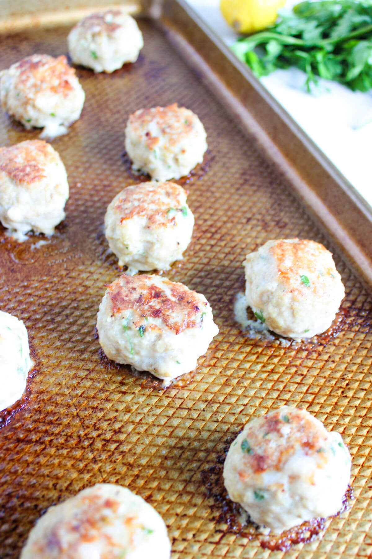 Chicken meatballs on a baking sheet.
