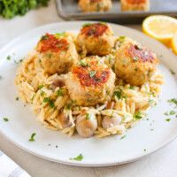 Chicken meatballs with orzo on a serving plate.