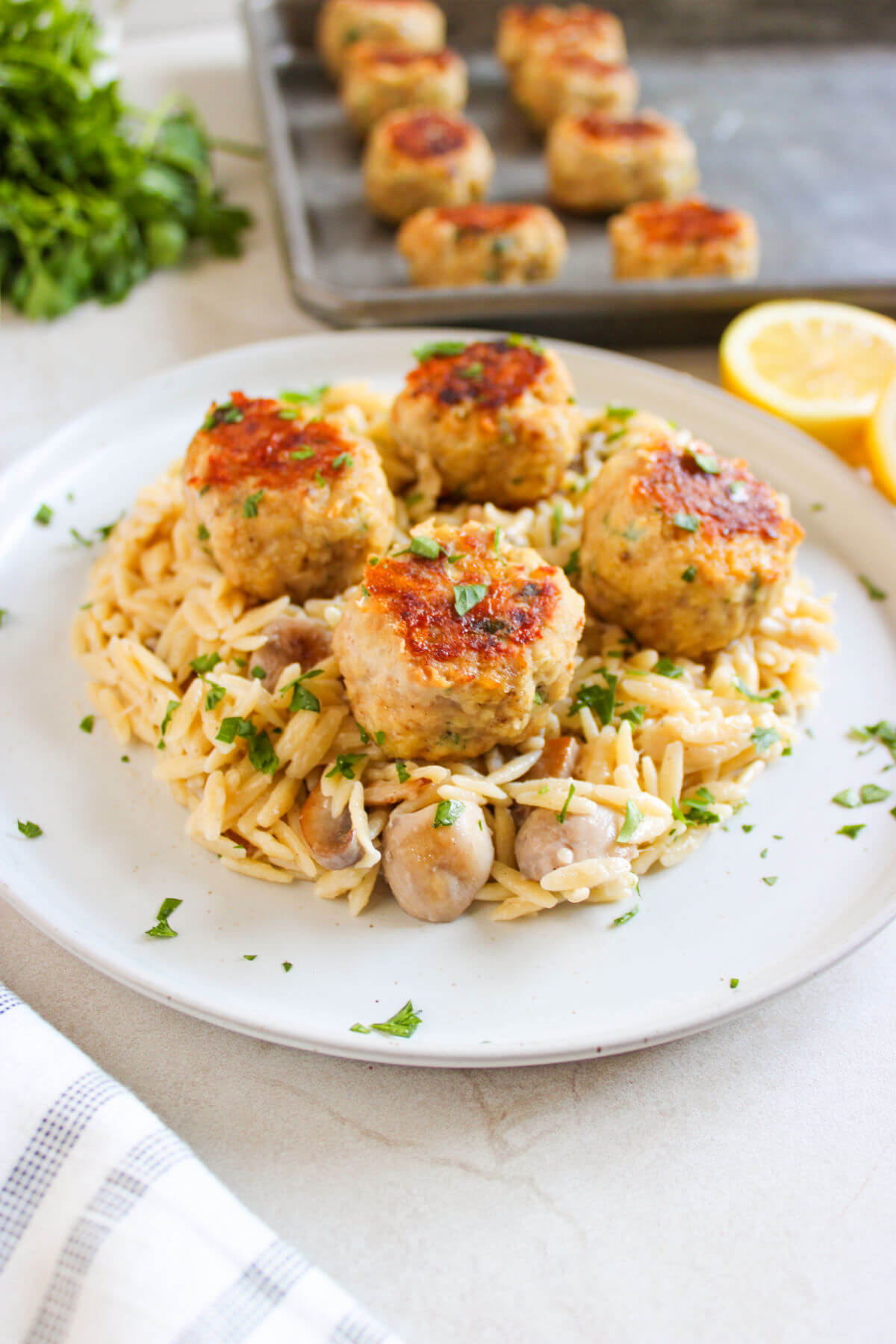 Chicken meatballs with orzo on a serving plate.