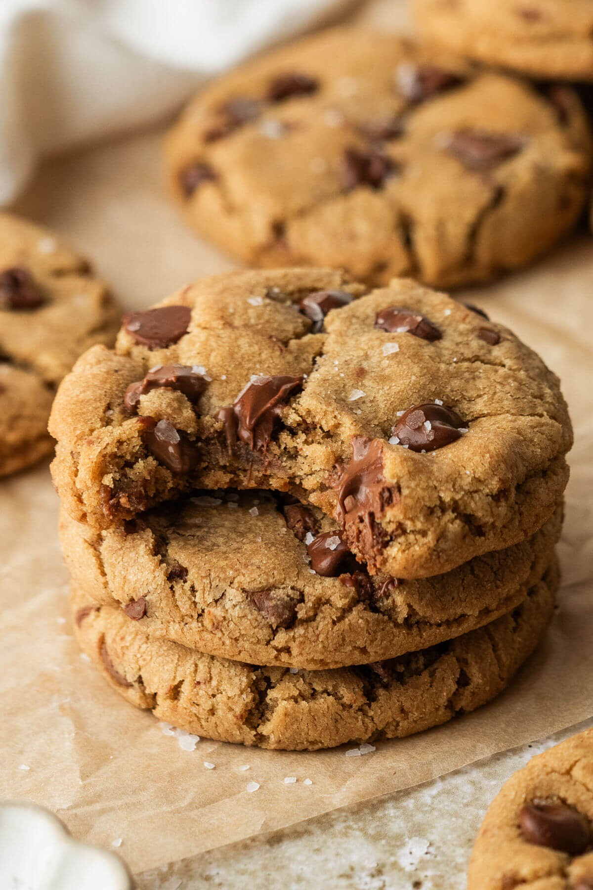 A stack of brown butter chocolate chip cookies with a bite taken out of one.