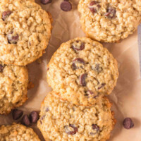 Sourdough oatmeal chocolate chip cookies on a piece of parchment paper after baking.