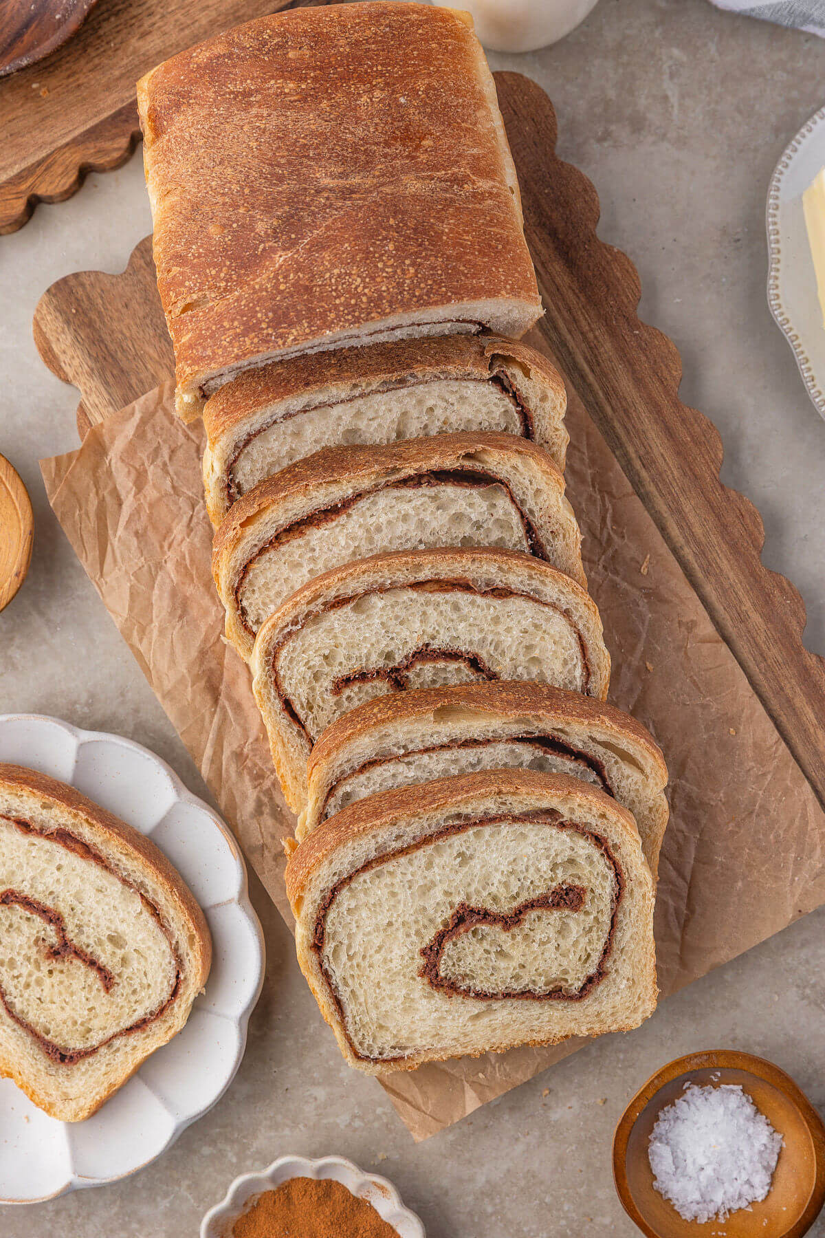 Sourdough cinnamon swirl bread cut into slices on a cutting board.