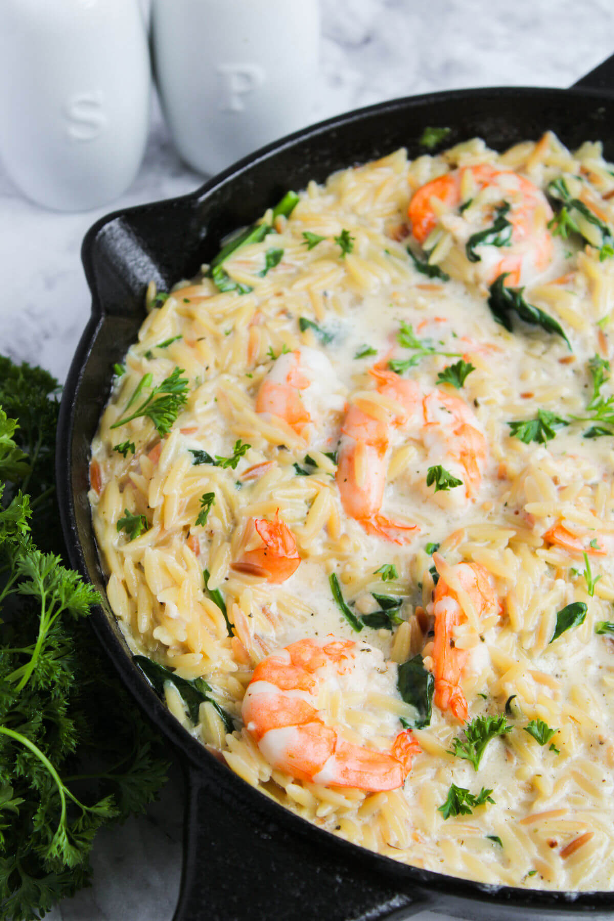 Lemon garlic shrimp orzo in a cast iron skillet after cooking.