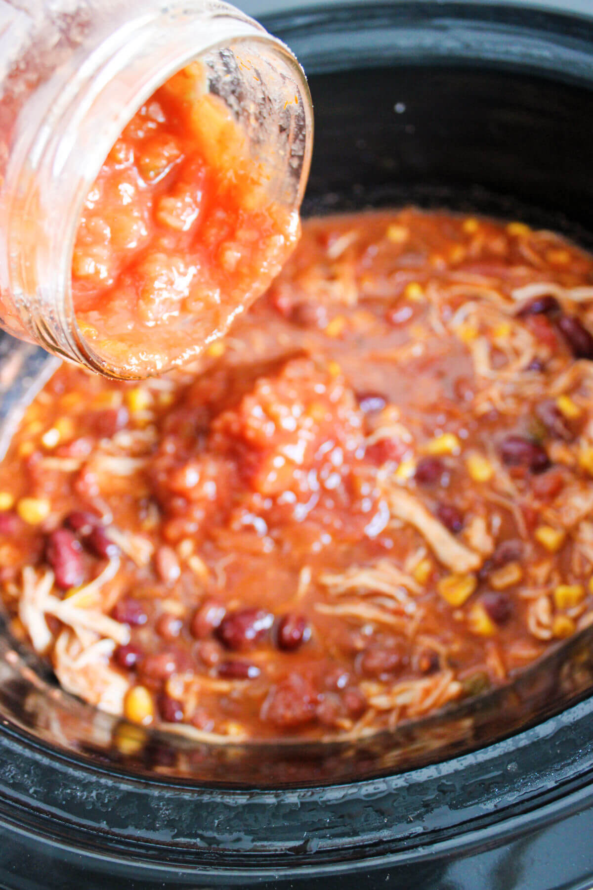 Salsa being added to crockpot.
