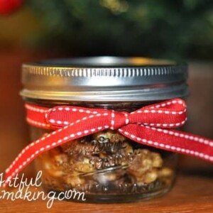 healthy homemade candied nuts in a glass jar tied with red ribbon