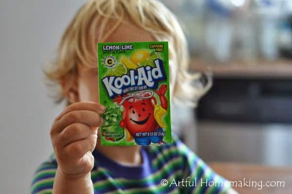child holding a Kool-Aid packet