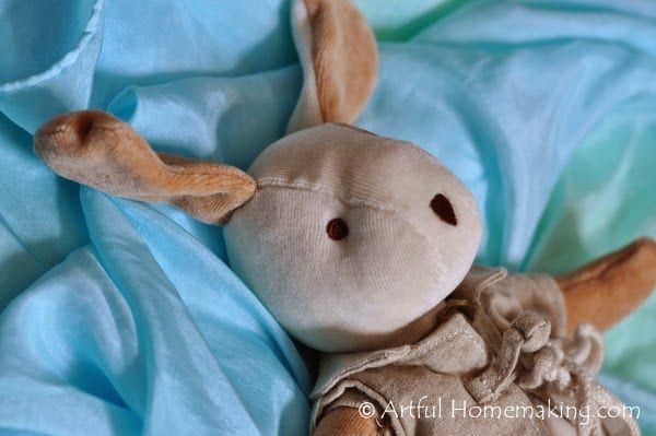 a toy rabbit with a blue play silk