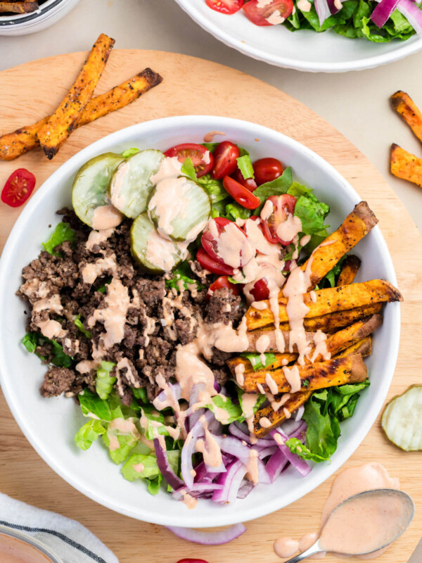 Burger bowls with special sauce in a bowl for serving.