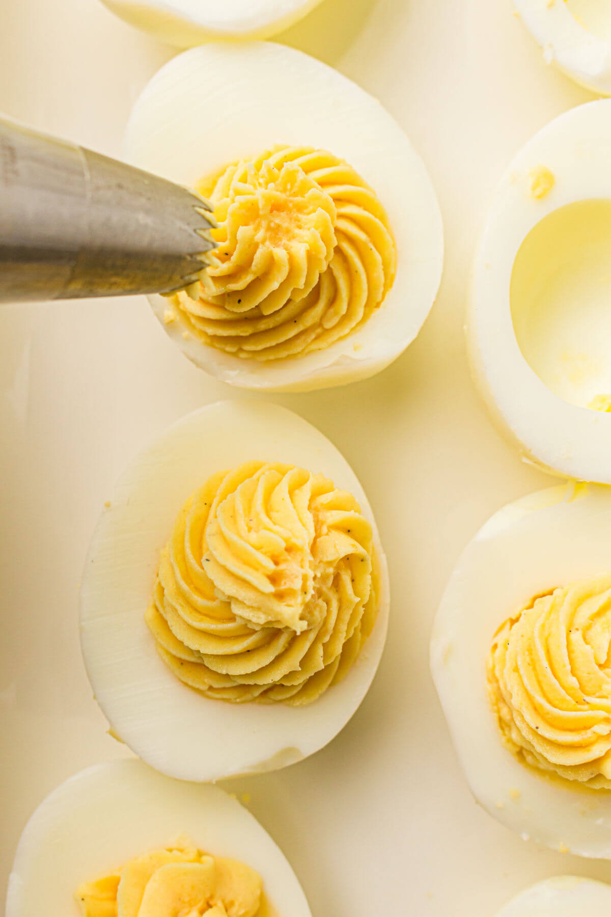 Piping egg filling for easy deviled eggs into the cooked egg whites.