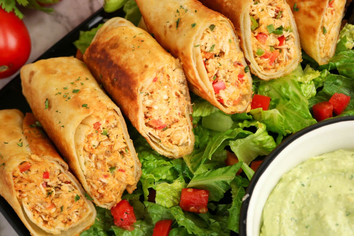 Firecracker chicken wraps on a bed of lettuce.