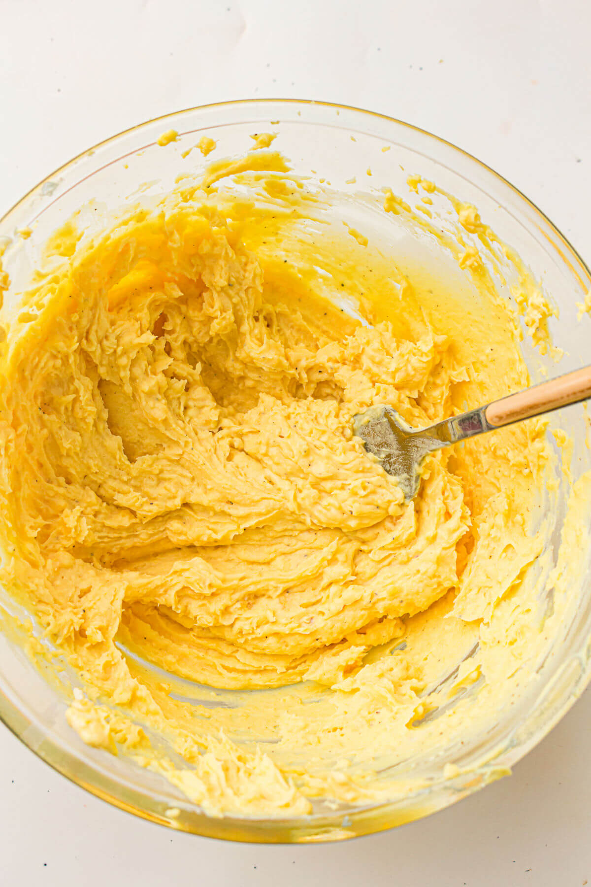 Creamy deviled eggs filling in a mixing bowl after mixing together.