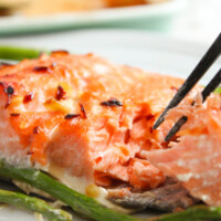 Honey glazed salmon with asparagus on a plate.