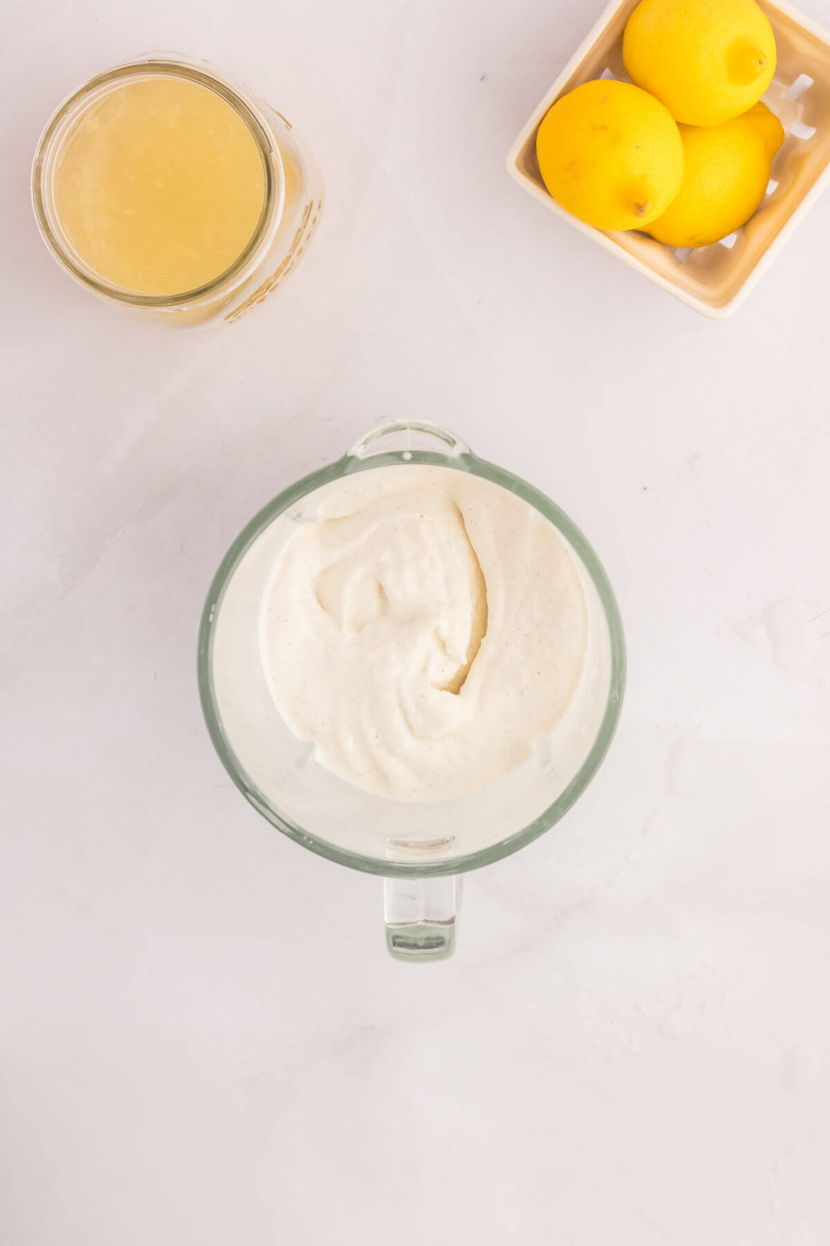 Ice cream and lemonade being blended together in a glass blender.