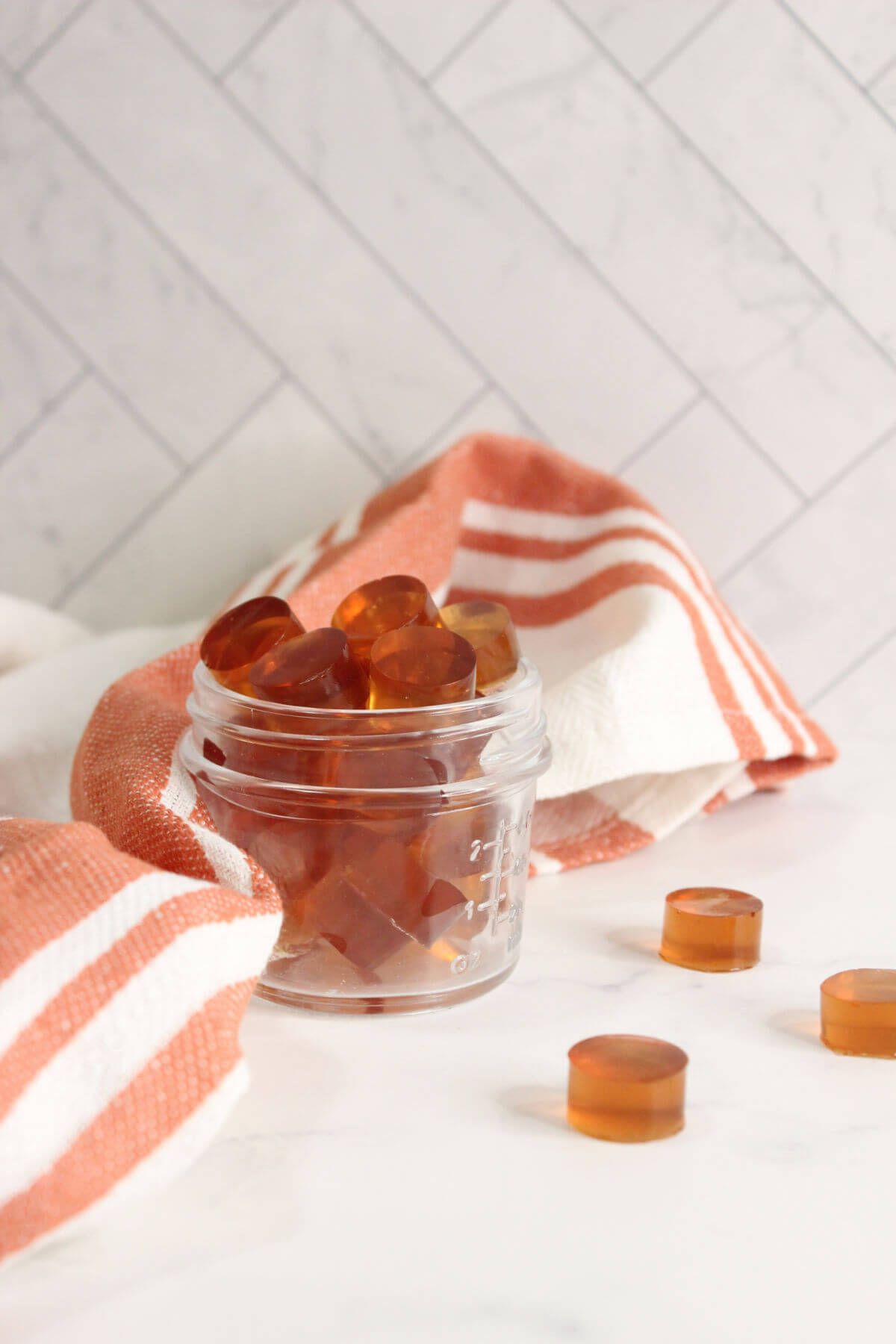 healthy gummies made with juice in a jar next to a striped towel
