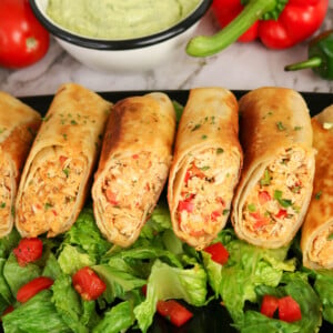 Firecracker chicken wraps on a bed of lettuce.