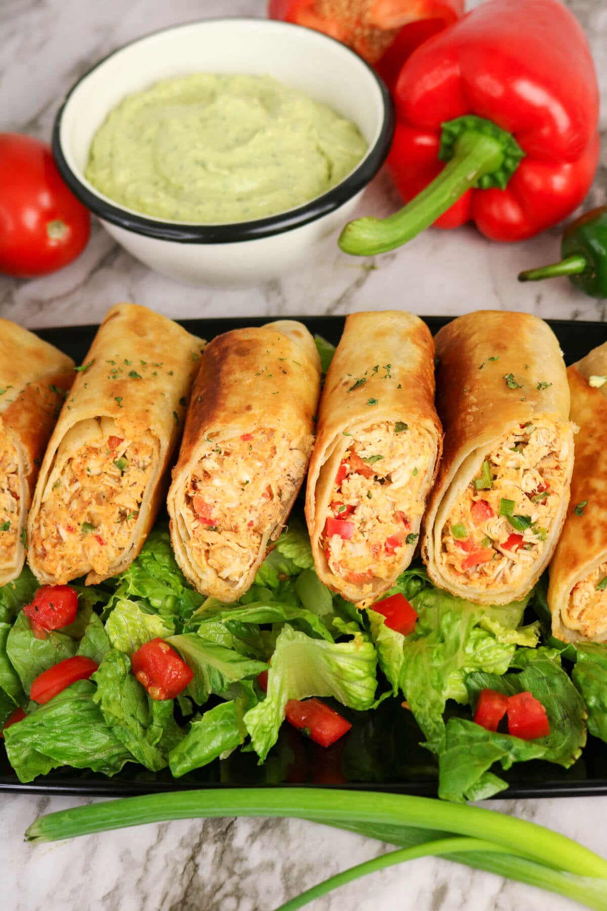Firecracker chicken wraps on a bed of lettuce.