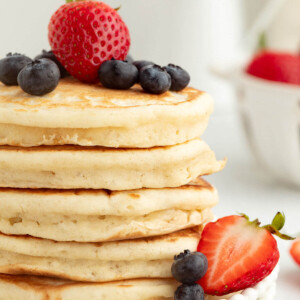 Fluffy sourdough pancakes with berries on top.