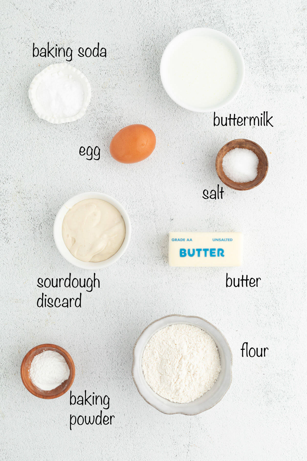 Ingredients for fluffy sourdough pancakes with text overlay labeling each ingredient.