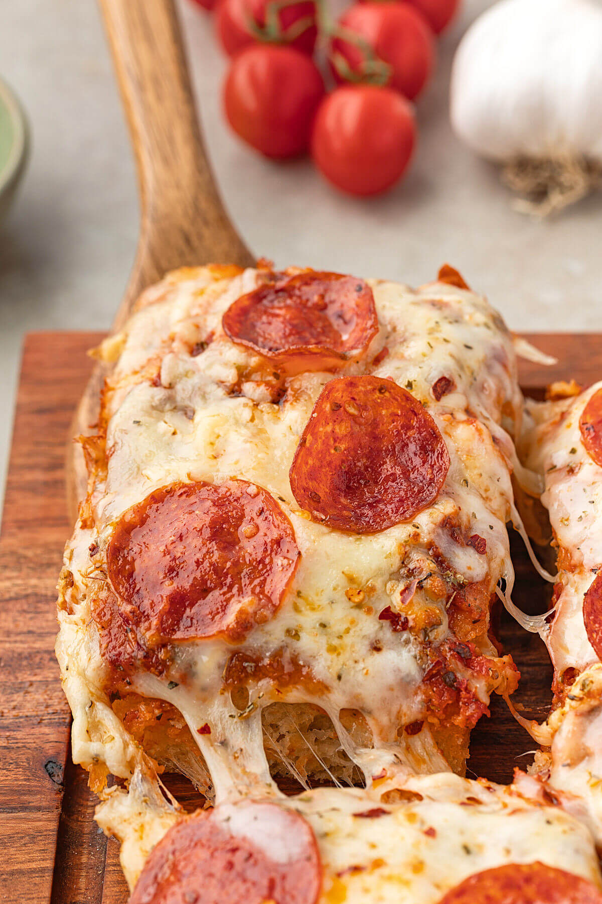 Sourdough discard focaccia pizza being served with a wooden spatula.