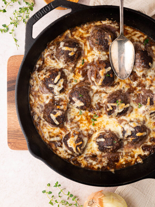 French onion meatballs in a large cast iron skillet.