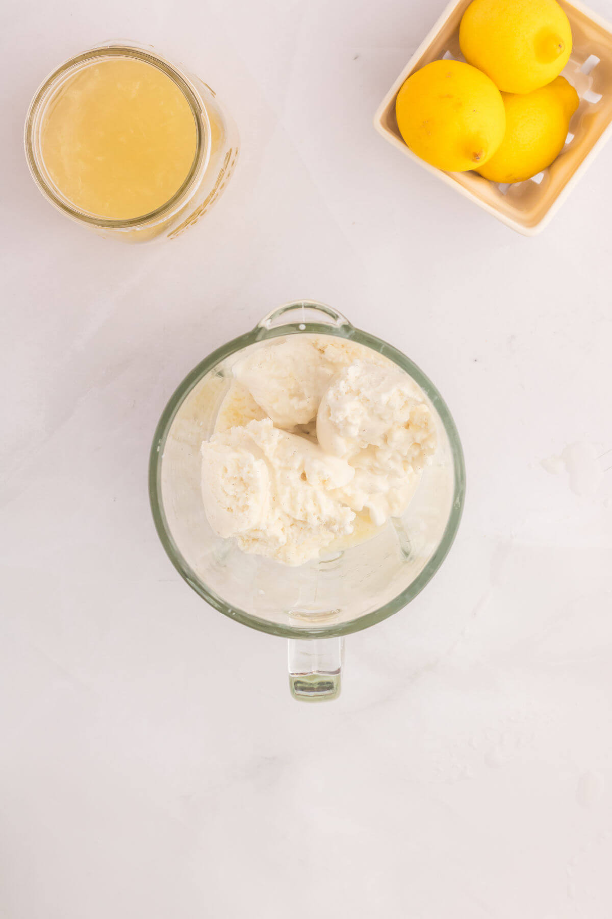 Adding the vanilla ice cream to a blender for the frosted lemonade recipe.