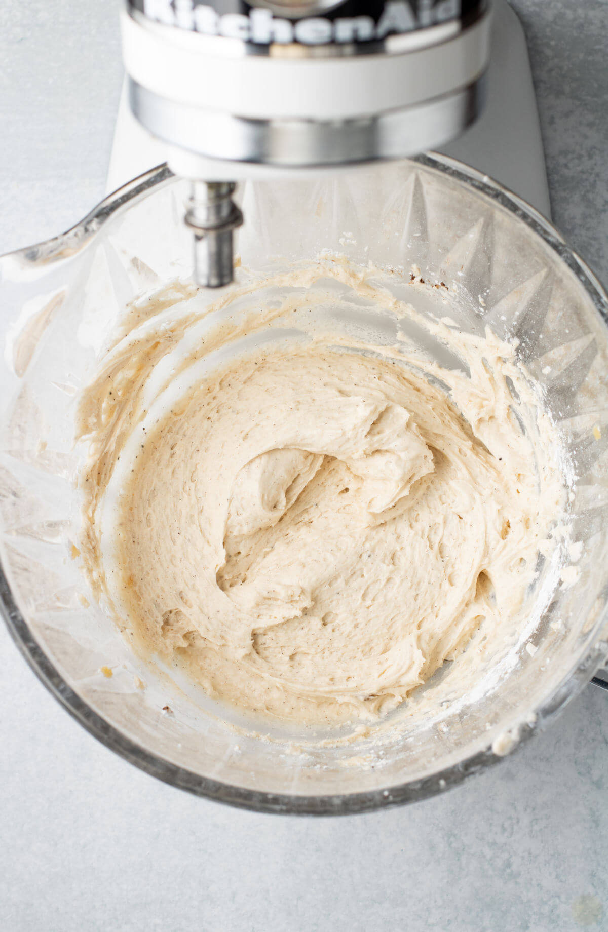 Making frosting in a glass kitchenaid bowl for chocolate chip cinnamon rolls.