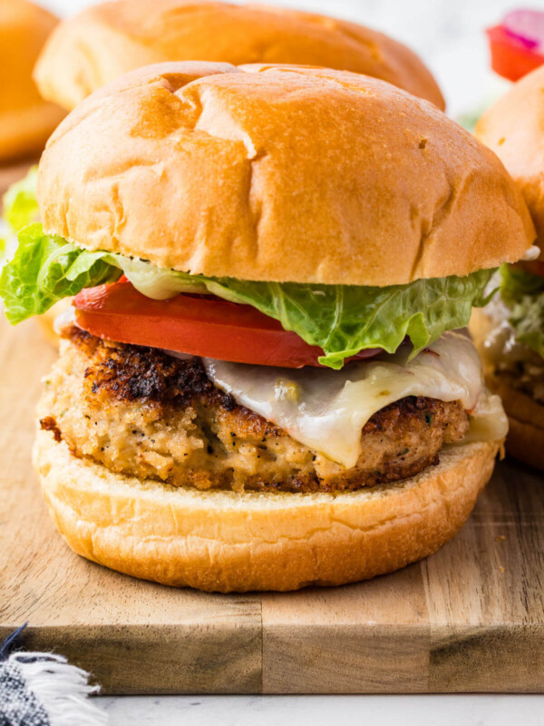 Chicken burgers on a cutting board.