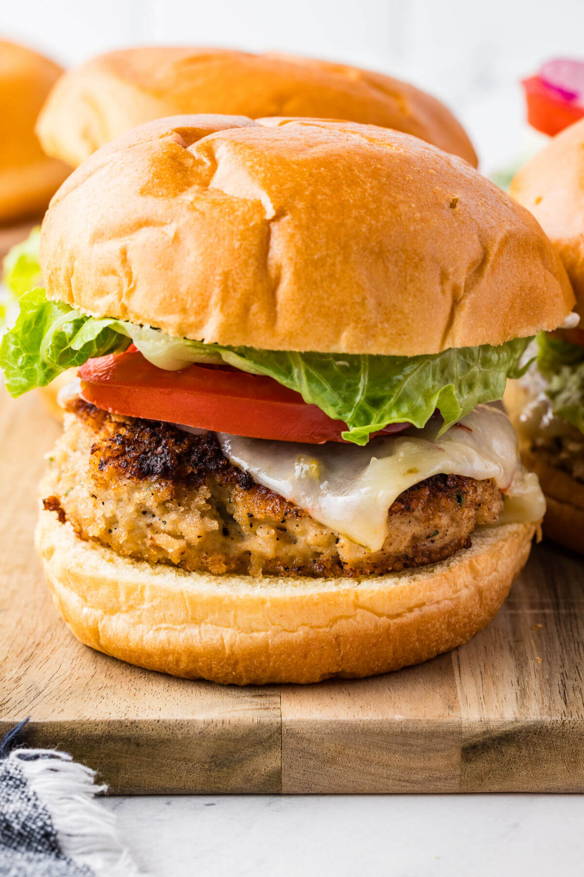 Chicken burgers on a cutting board.