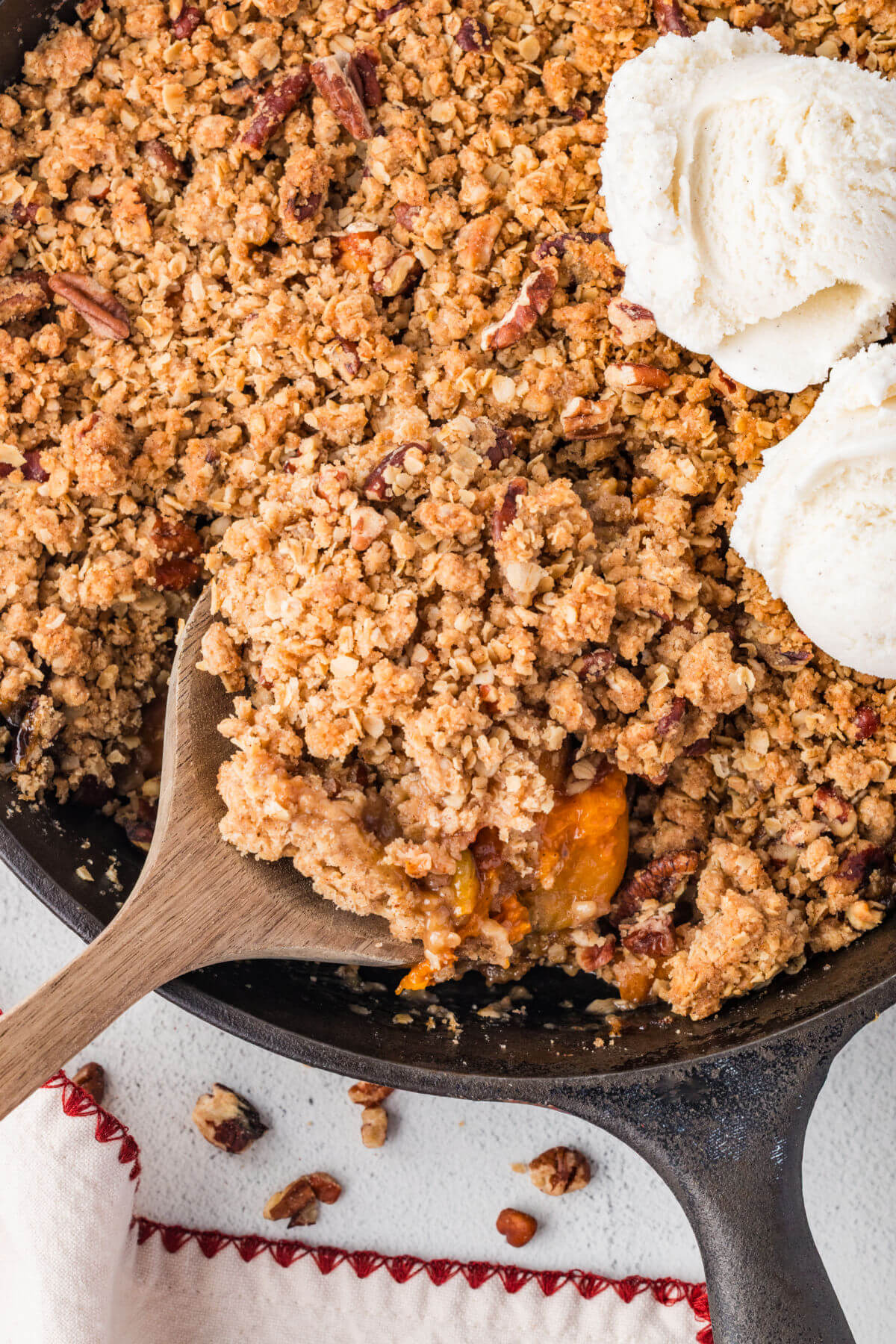 Serving apricot crumble with a wooden spoon.