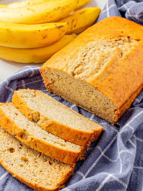 A loaf of quick and easy banana bread cooling on a tea towel.