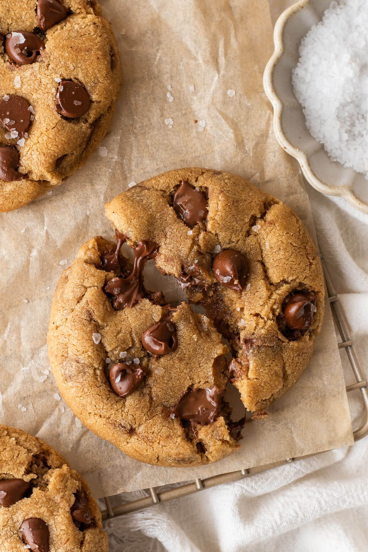 Brown butter chocolate chip cookies with one broken in half, showing melted chocolate.