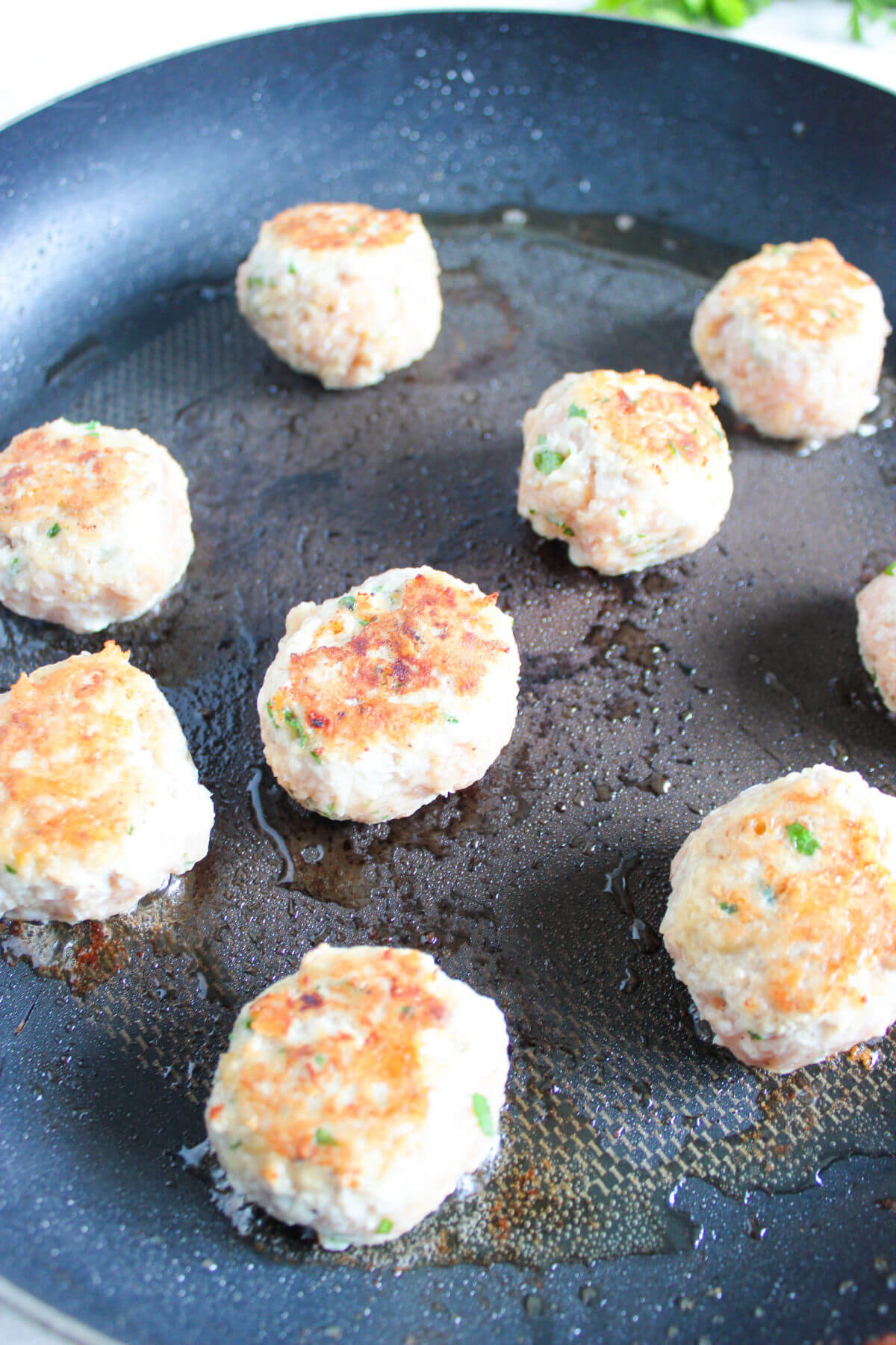 Browning chicken meatballs to serve with orzo.
