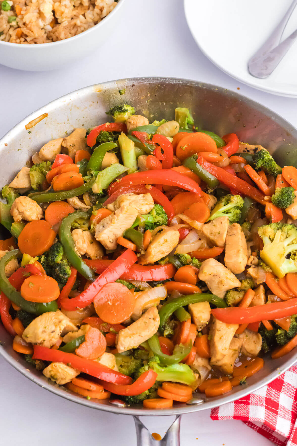 Simple chicken stir-fry with vegetables in a stainless steel skillet.