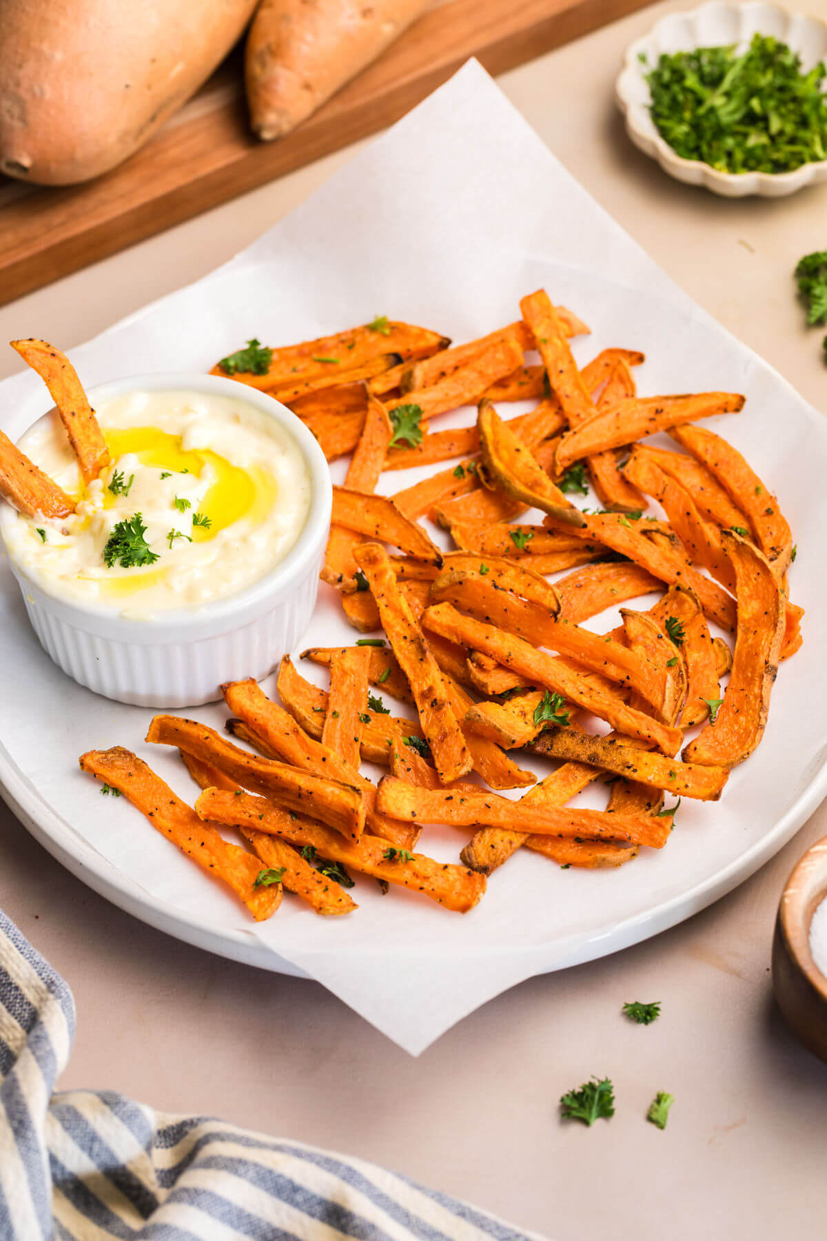 A plate of crispy sweet potato fries with aioli sauce.