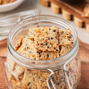 Everything sourdough discard crackers in a glass jar.