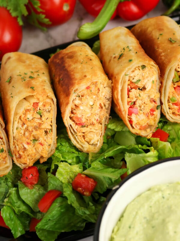 Firecracker chicken wraps on a bed of lettuce.
