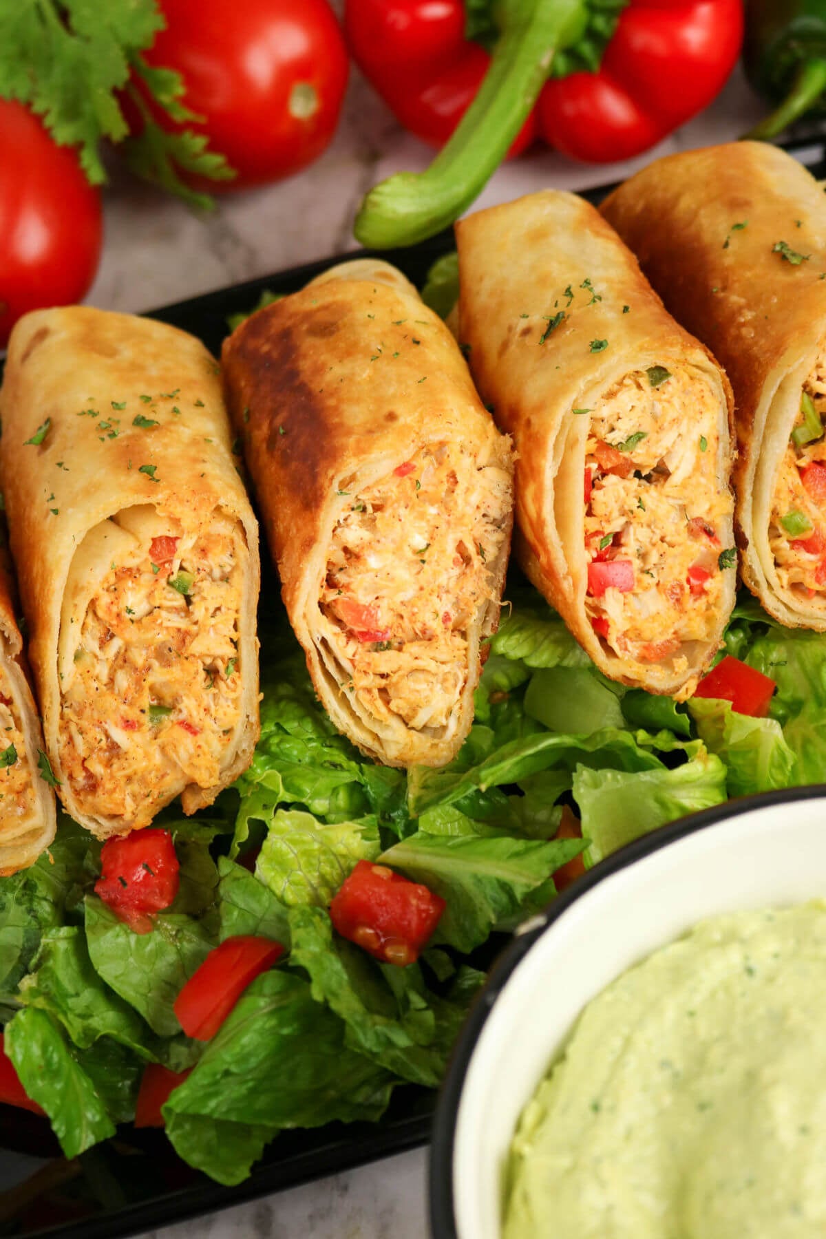 Firecracker chicken wraps on a bed of lettuce.