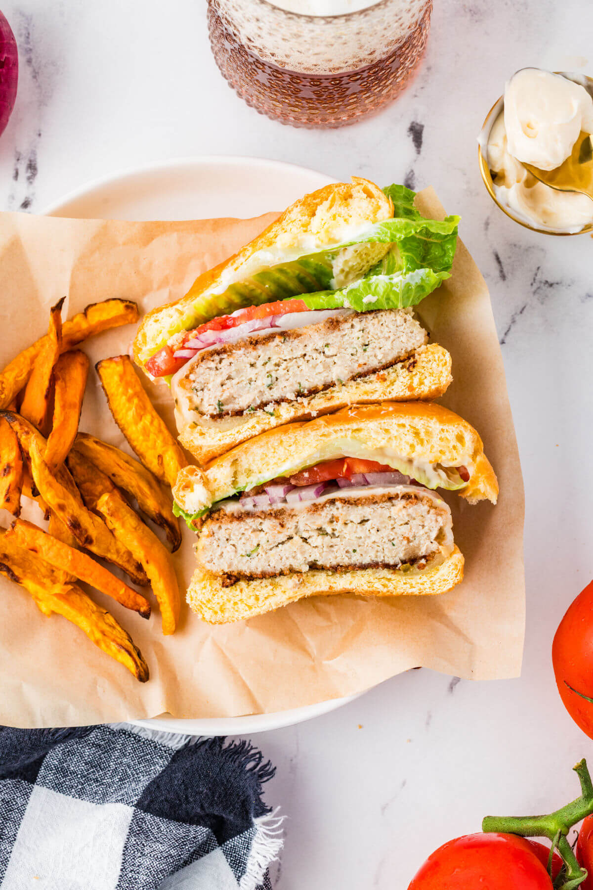 Chicken burgers cut in half on a plate.