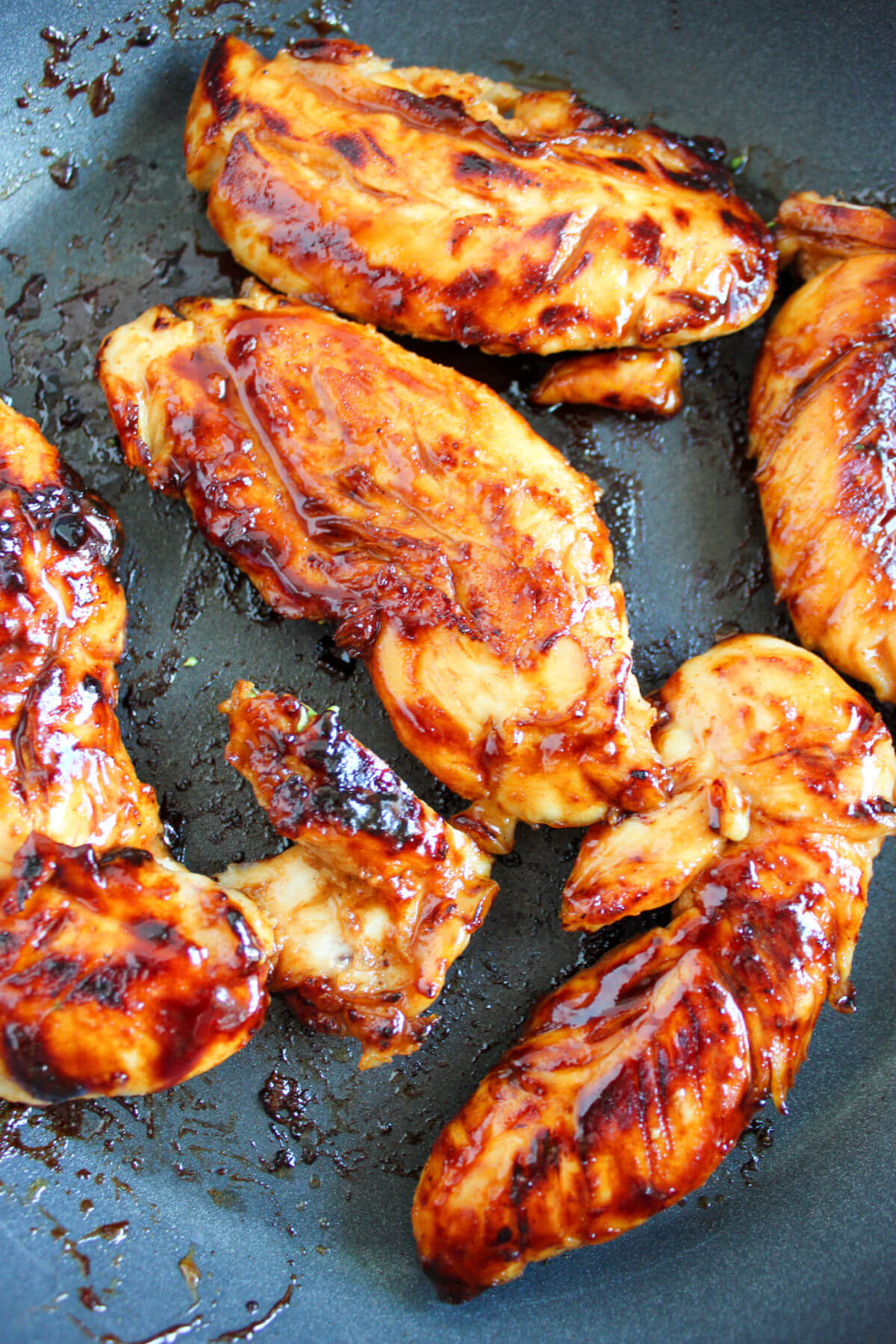 Honey mustard chicken tenders cooking in a skillet.